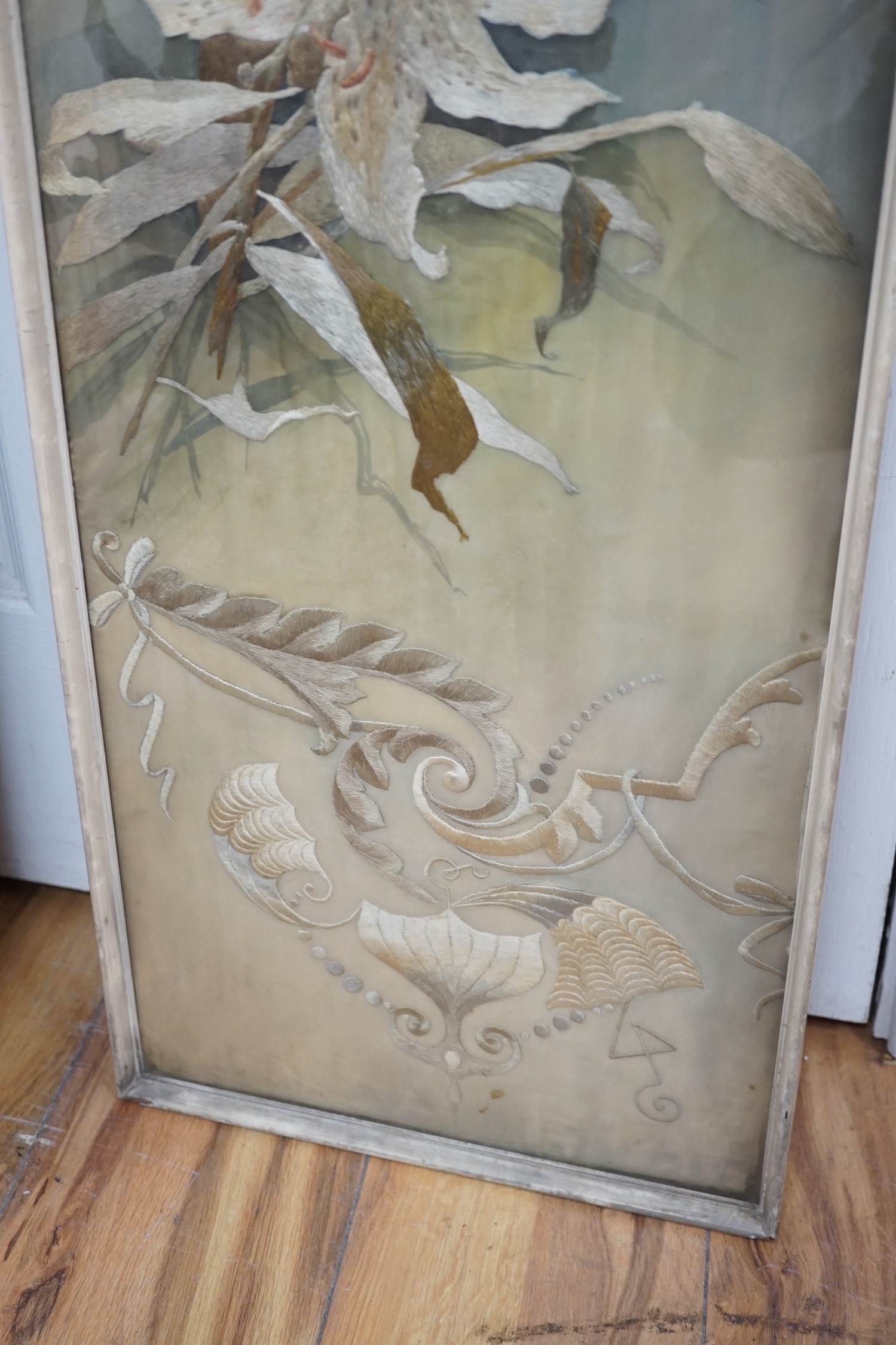 A framed silk embroidered panel, possibly French, cut from a larger piece, 137cms high x 27wide